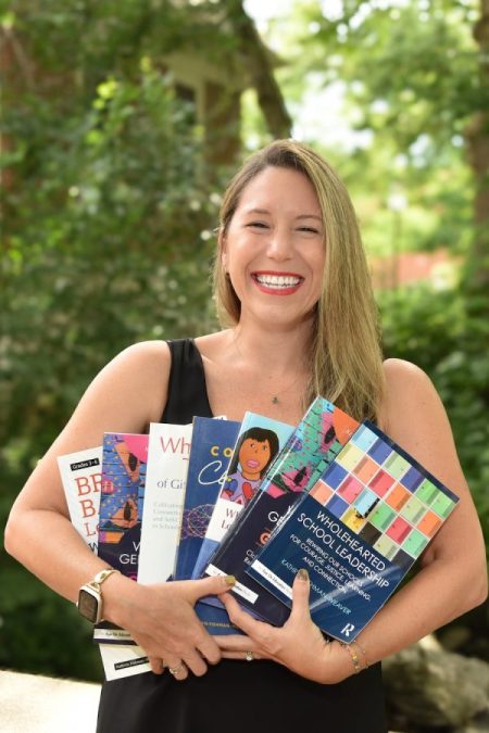 Image of Dr. Kathryn Fishman-Weaver holding books.