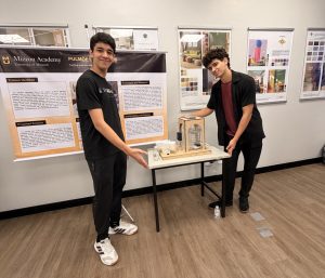 A pair of students present their poster and demonstration.