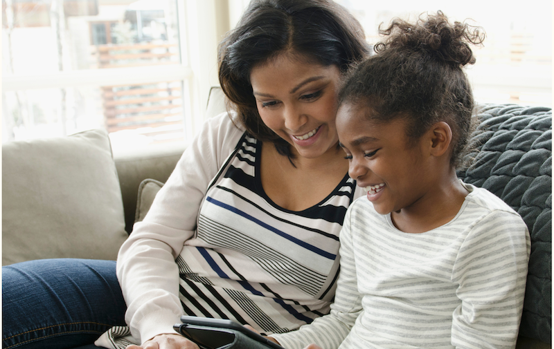 A woman and a child working with a tablet.